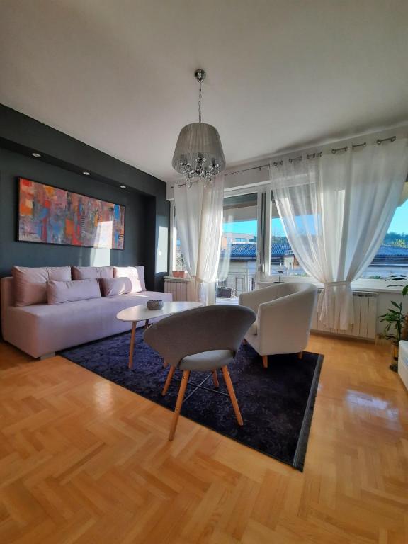 a living room with a couch and a table and chairs at Apartman Aylin in Tuzla