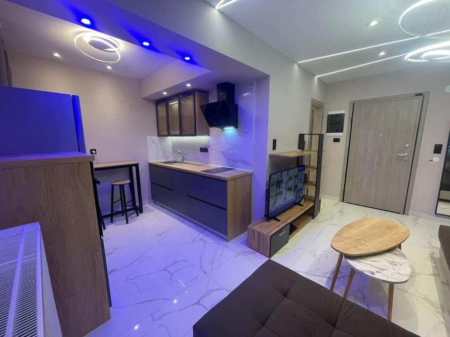 a large kitchen with a tv and a table at Lydia Luxury Apartment by the Sea in Perea
