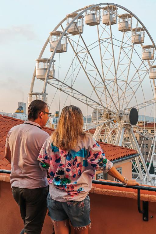 a man and woman standing next to a ferris wheel at L'Eautel Toulon Centre Port in Toulon