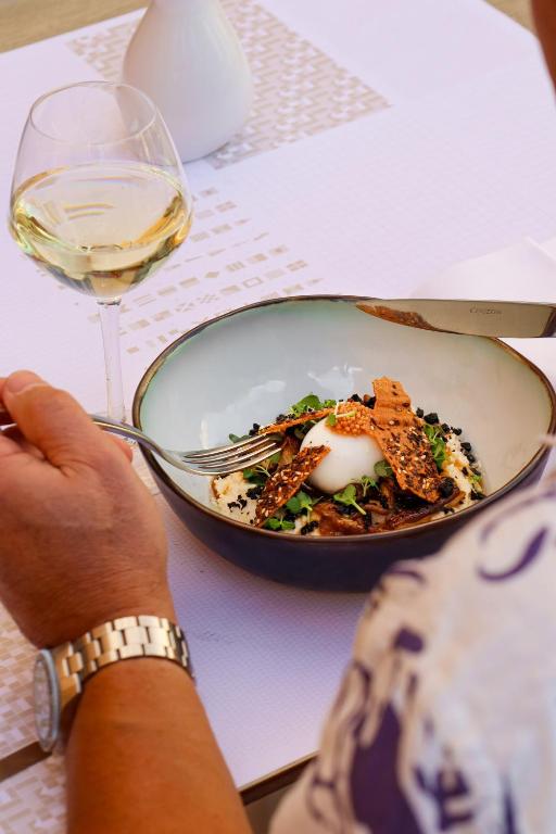 a person holding a plate of food and a glass of wine at L'Eautel Toulon Centre Port in Toulon