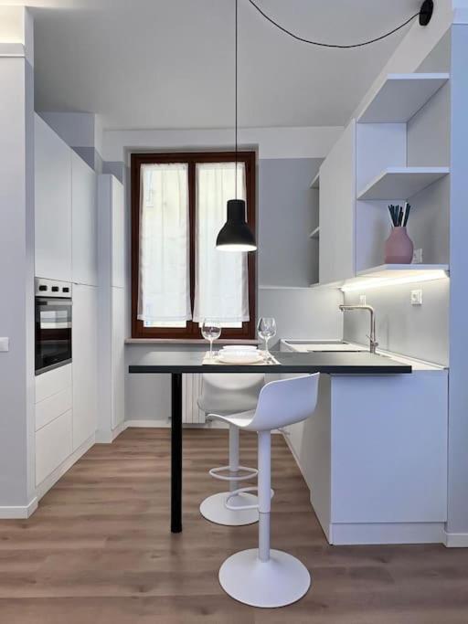 a white kitchen with a table and chairs in it at Comfort moderno centro città in Ancona
