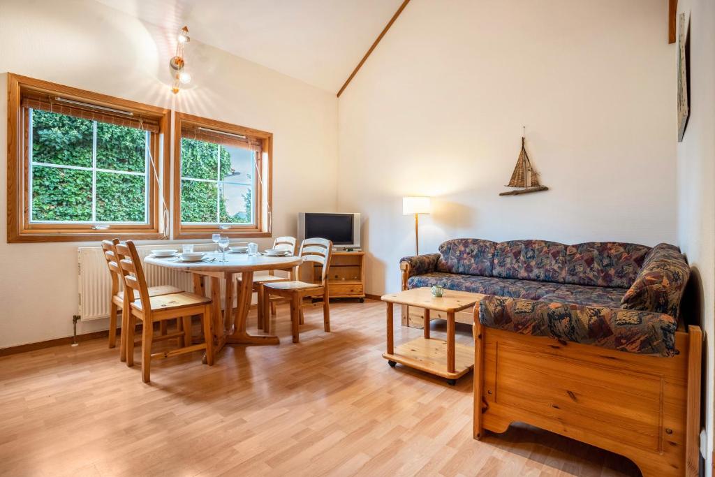 un salon avec un canapé et une table dans l'établissement Haus Albatros Wohnung 5, à Ostseebad Koserow