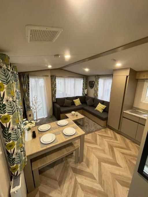 a living room with a table and a couch at BRAND NEW 6 berth holiday home in Selsey