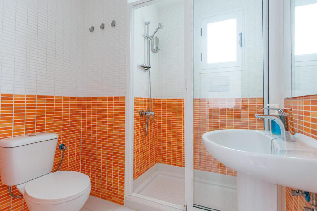 a bathroom with a toilet and a sink and a shower at Las Casitas de Corralejo in Corralejo
