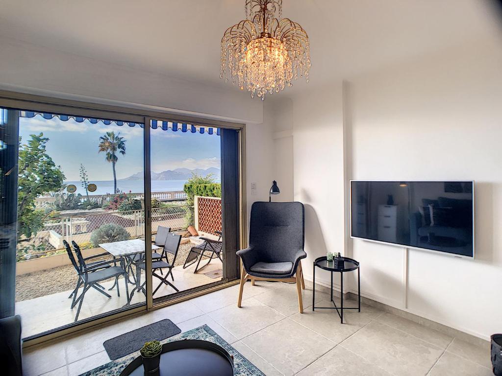 d'un salon avec un lustre et une vue sur un patio. dans l'établissement Front de mer 231L, à Cannes