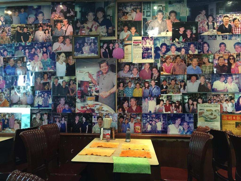 New Orchid Hotel في سنغافورة: طاولة في مطعم مع صور على الحائط
