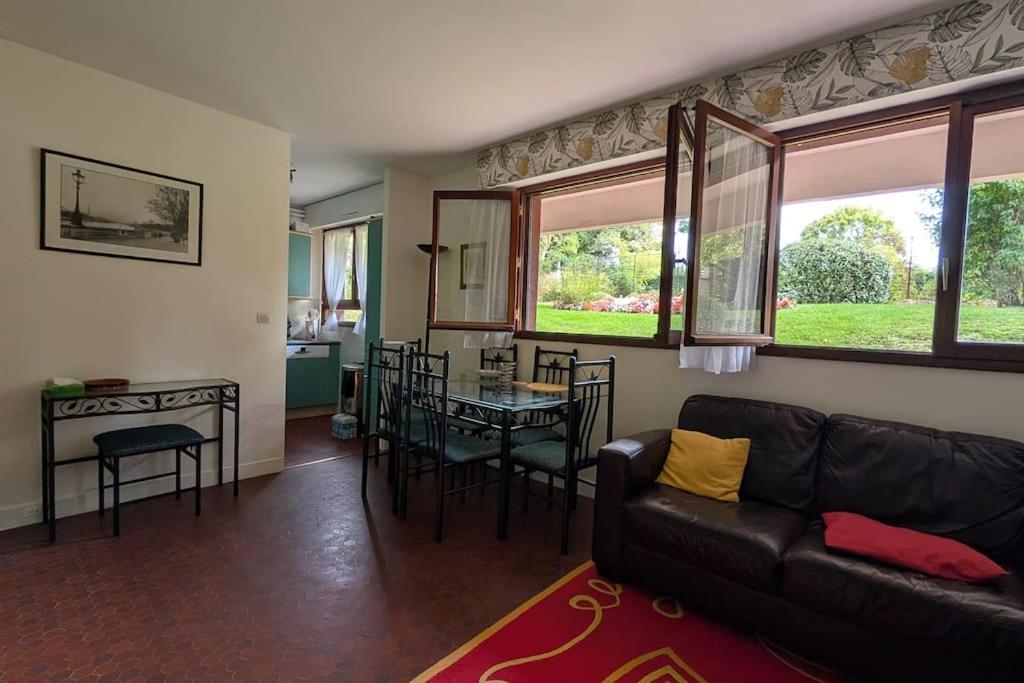 a living room with a couch and a table at La Clé de Jane in Chatou