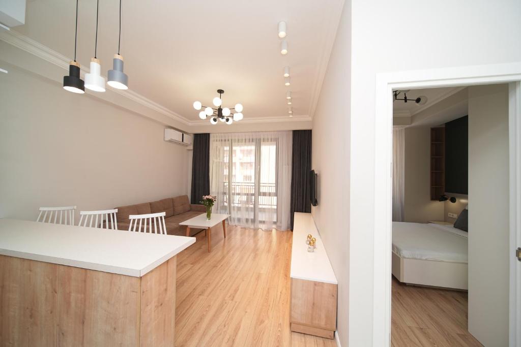 埃里温Modern apartments in the heart of Yerevan by Sweet Home的一间带厨房的客厅和一间带一张床的房间