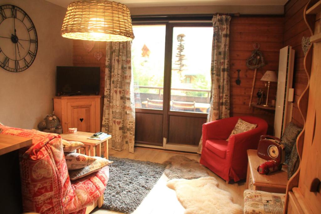 - un salon avec une chaise rouge et une fenêtre dans l'établissement Anna Maria AN37 COSY & NATURE 4 Pers, à Châtel