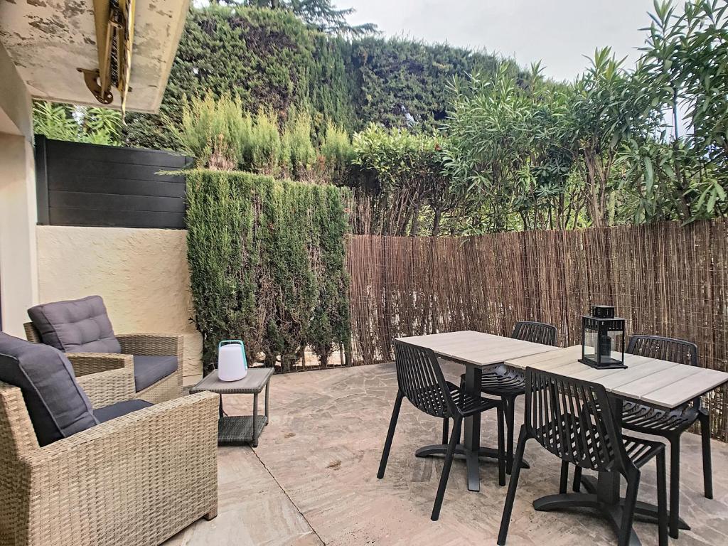 un patio avec une table et des chaises et une clôture dans l'établissement Belles prestations, proche plages, piscine 232L PY, à Cannes