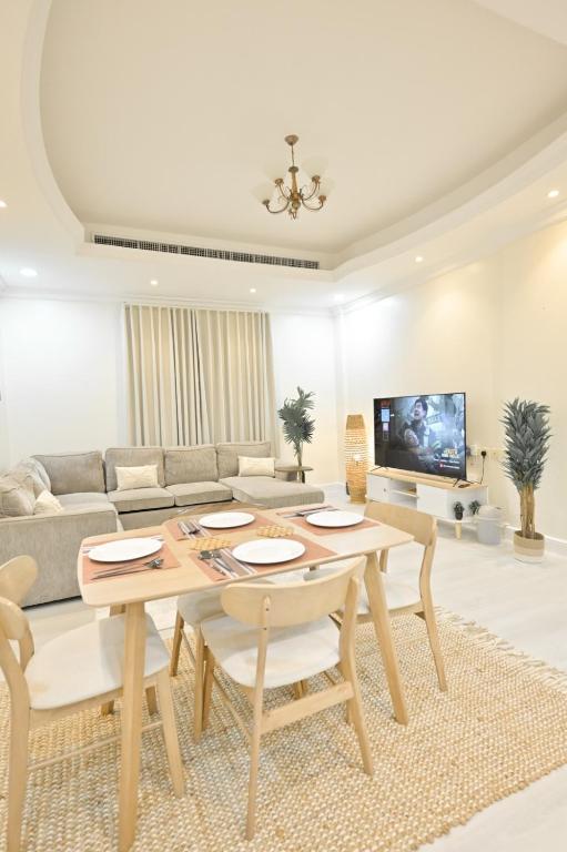 a living room with a table and a couch at RJ's - Beautiful 3 Bedroom Apartment in Al Khobar