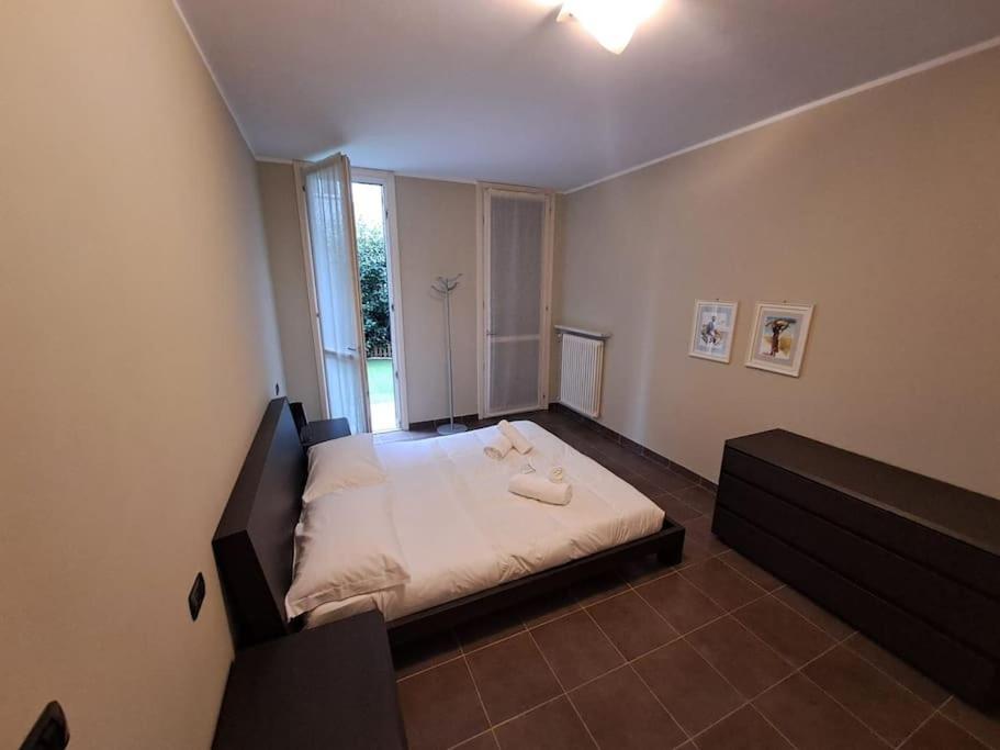 ein Schlafzimmer mit einem Bett mit weißer Bettwäsche und einem Fenster in der Unterkunft Casa da Umberto in Parma