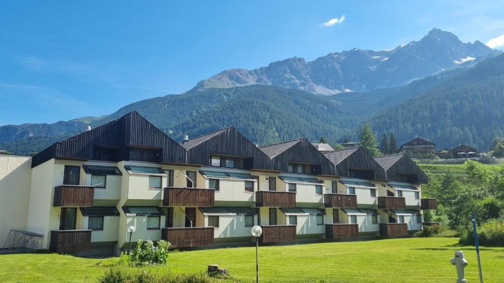 a building with balconies with mountains in the background at Residenza Tga Clo Apartment C20 in Savognin