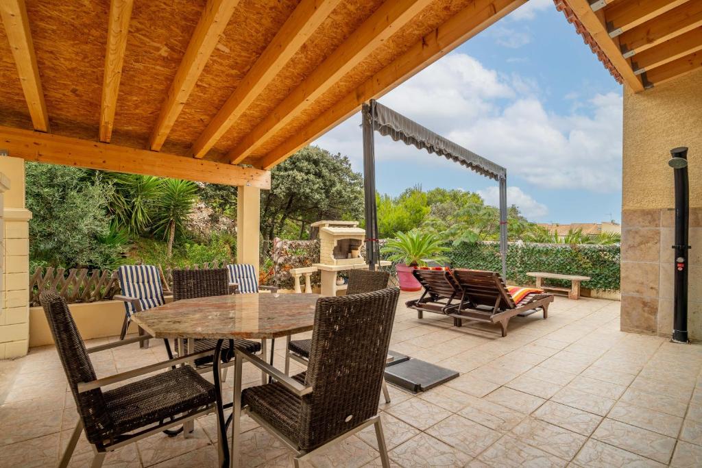 un patio avec une table, des chaises et un barbecue dans l'établissement Le Grand Lapin Blanc, à Fleury