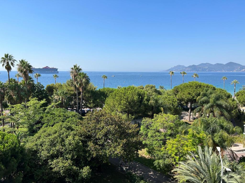 une vue sur l'océan depuis un complexe hôtelier avec des palmiers dans l'établissement Superbe 4 pièces vue mer 320L DEL, à Cannes