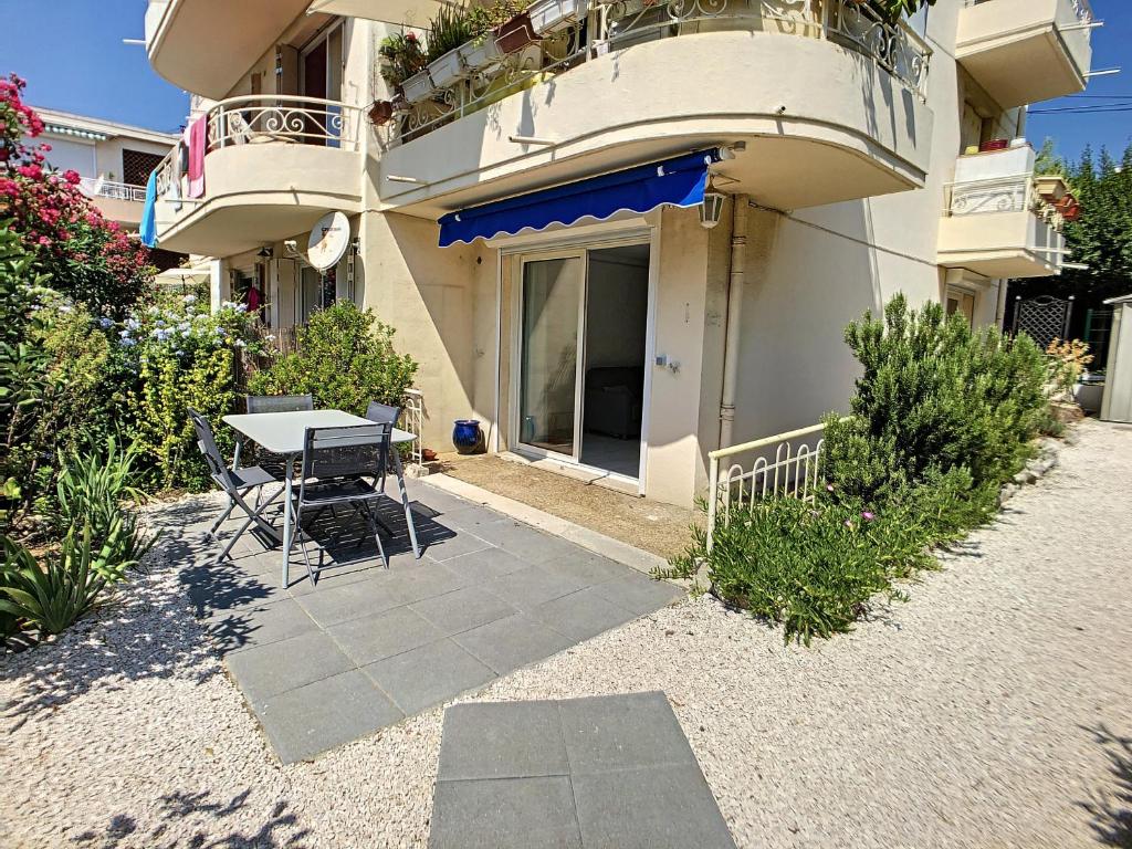 un patio avec une table et des chaises devant un bâtiment dans l'établissement A deux pas des plages du Midi - 293L REYVE, à Cannes