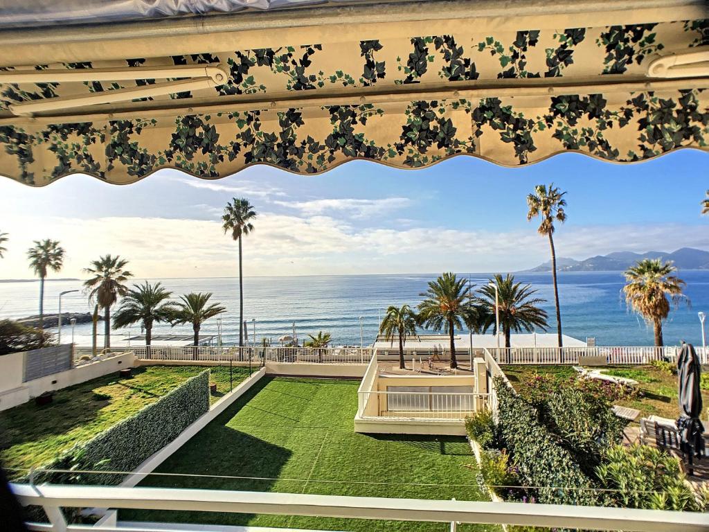 - une vue sur l'océan et les palmiers depuis le balcon d'un complexe dans l'établissement Front de mer, superbe terrasse vue mer 283L CHANS, à Cannes