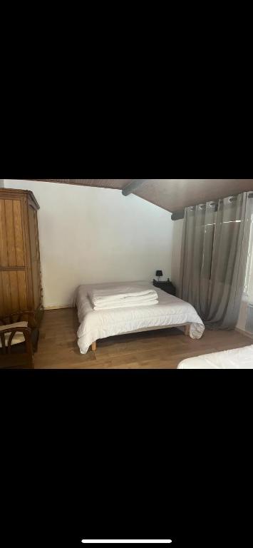 - une chambre avec un lit et une fenêtre avec un rideau dans l'établissement Appartement chaleureux, à La Bollène-Vésubie