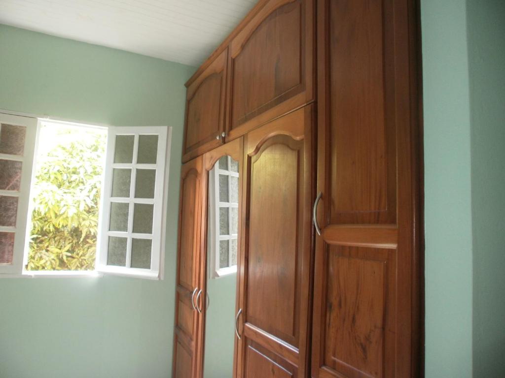 a wooden cabinet in a room with a window at Villa Grandes pièces in Petit-Bourg