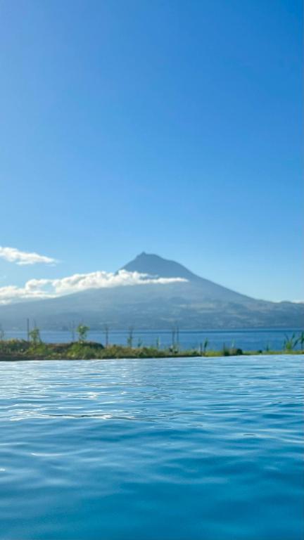 a view of a body of water with a mountain in the background at Almoxarife Beach House in Praia do Almoxarife