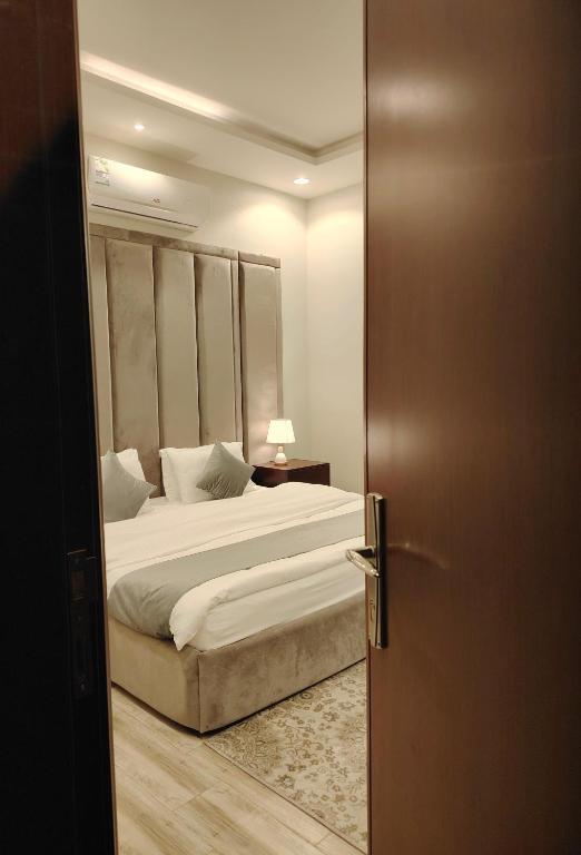 a bedroom with a bed and a open door at أجنحة دارك للشقق المخدومة - Ajnihat Dark Serviced Apartments in Ad Dawādimī