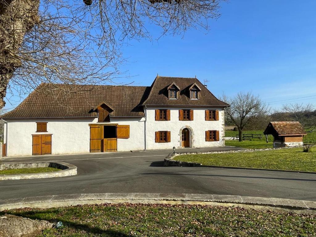 a white house with a brown roof on a road at Loustaou in Osserain-Rivareyte