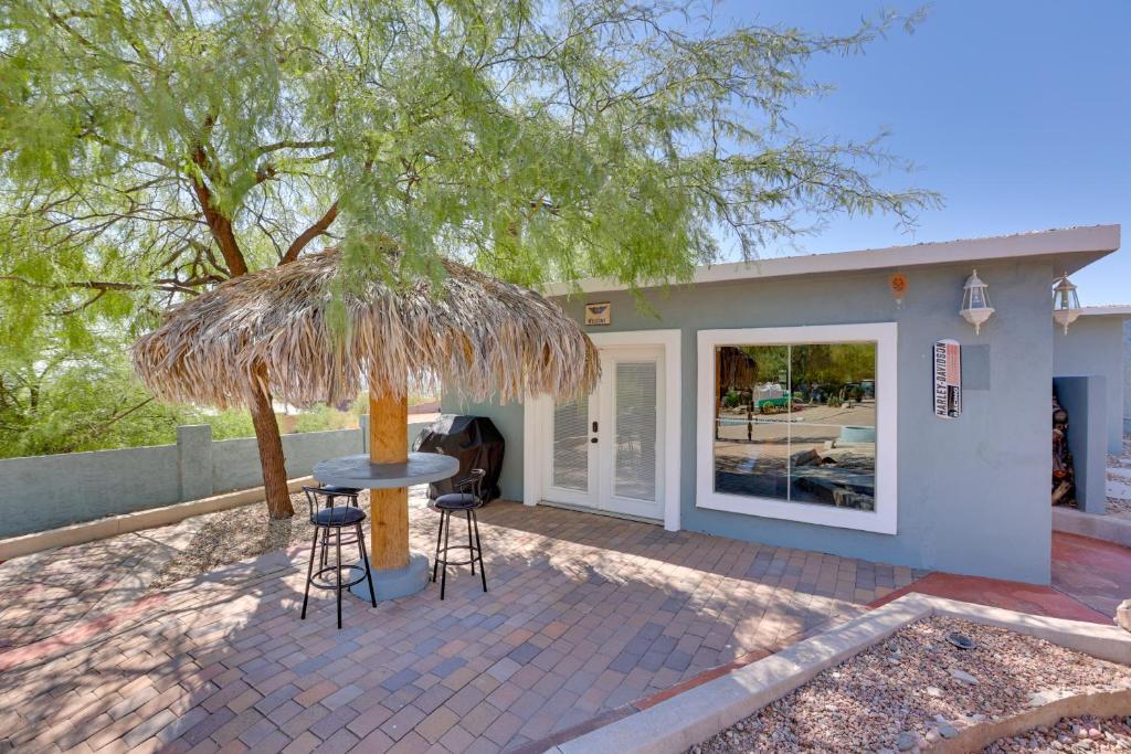 阿帕奇章克申Patio with Desert Views Apache Junction Abode的一个带桌子和椅子的稻草伞下庭院