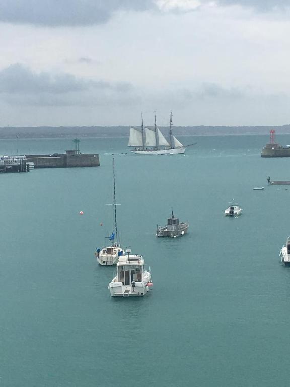 un groupe de bateaux dans une grande masse d'eau dans l'établissement les pieds dans l'eau, à Granville