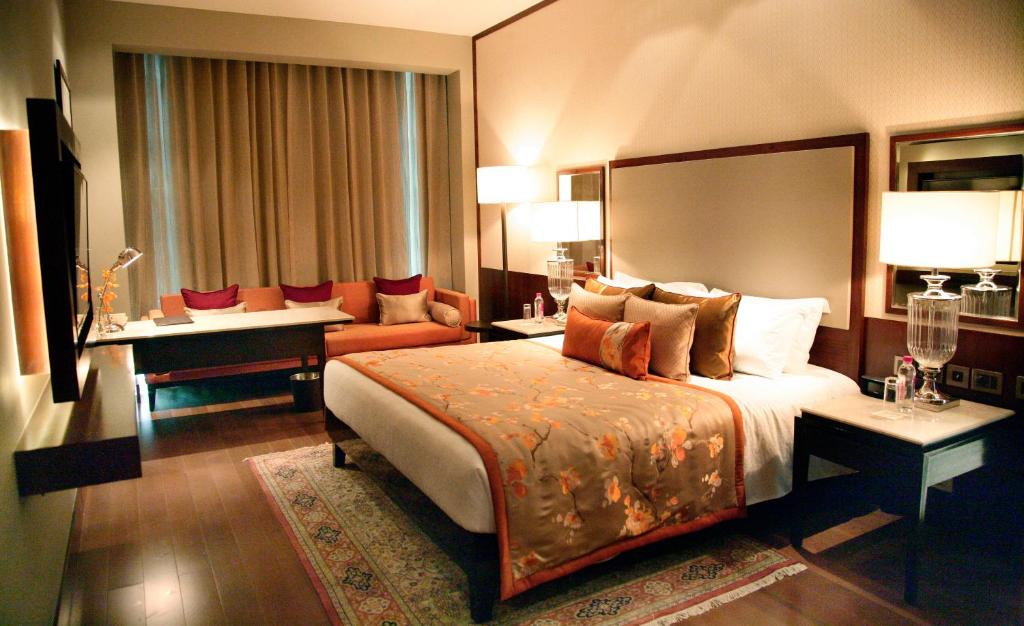a hotel room with a large bed and a desk at Taj Bangalore in Devanahalli-Bangalore