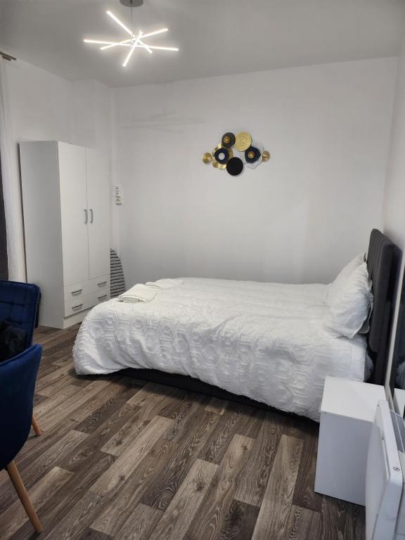 une chambre avec un lit et une horloge au mur dans l'établissement Studio proche Paris, à Saint-Denis