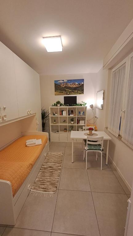 a bedroom with a bed and a desk and a table at Valtellina Sondrio Holidays 3 in Sondrio