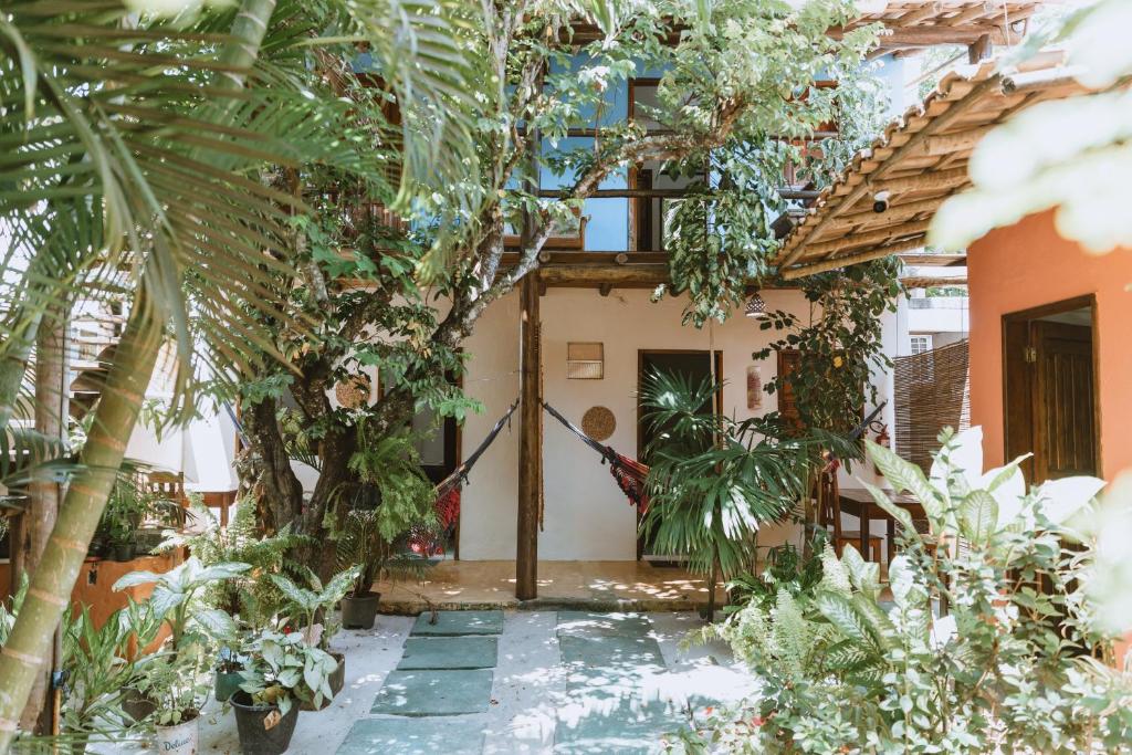 a courtyard of a house with trees and plants at Pousada Maria Dajuda Caraiva in Caraíva
