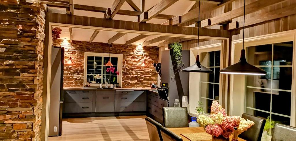 a kitchen with a stone wall and a table with chairs at Fantastisk feriehus på Tretten, Hafjell in Tretten