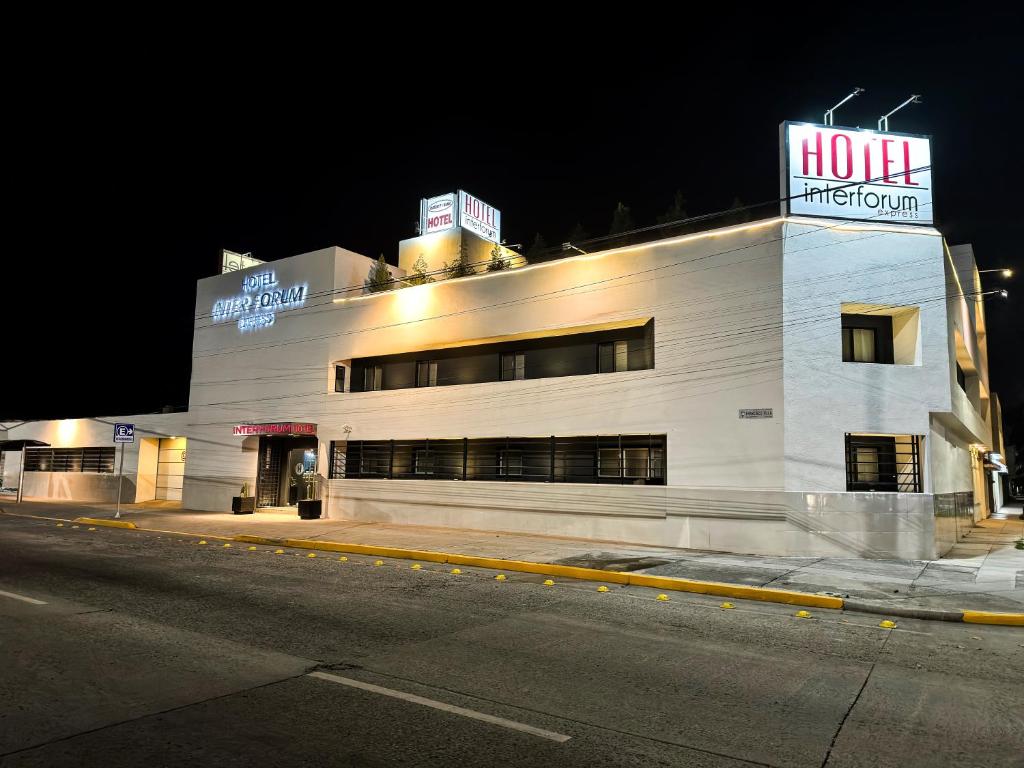 Un gran edificio blanco en una calle por la noche. en Hotel Interforum, en León