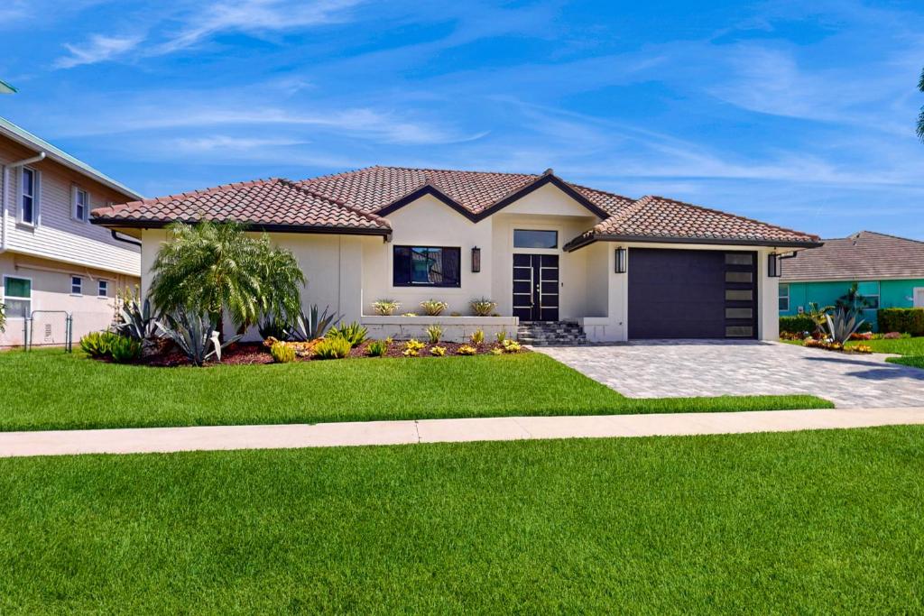 ein Haus mit grünem Rasen in der Unterkunft Tropical Treasure Retreat in Marco Island