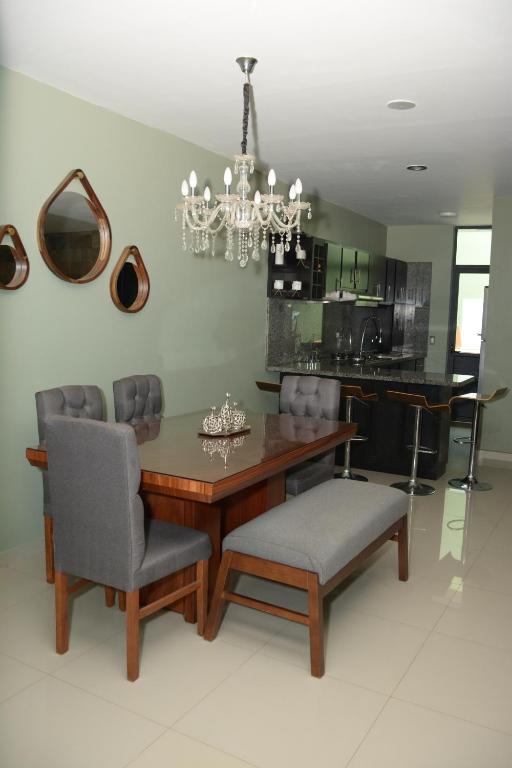 a dining room with a table and chairs and a chandelier at Comfort House La Herradura in Arandas