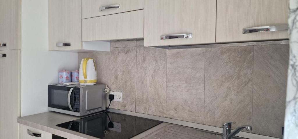 una piccola cucina con forno a microonde e lavandino di PACEVILLE St Julians Apartments a San Giuliano