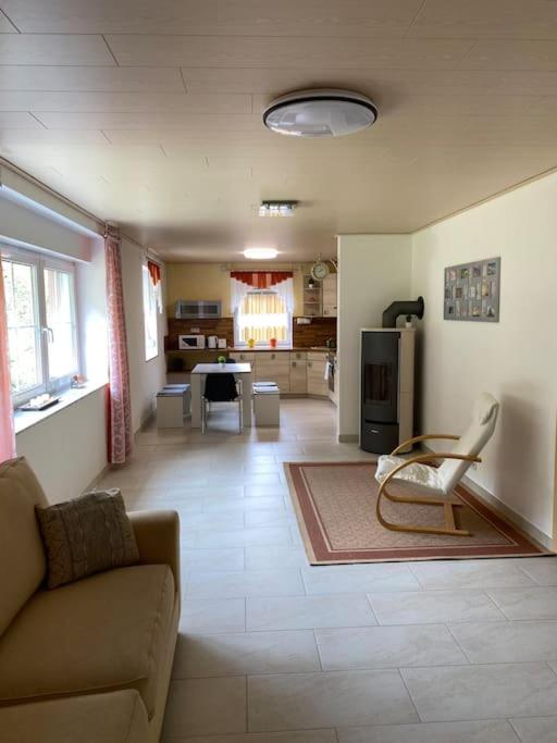 a living room with a couch and a kitchen at Ferienwohnung Bangert in Idar-Oberstein