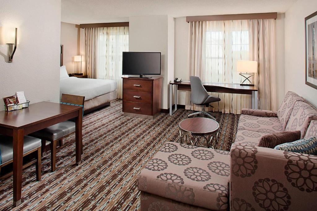 Una habitación de hotel con una cama, un sofá y un escritorio. en Residence Inn Worcester, en Worcester