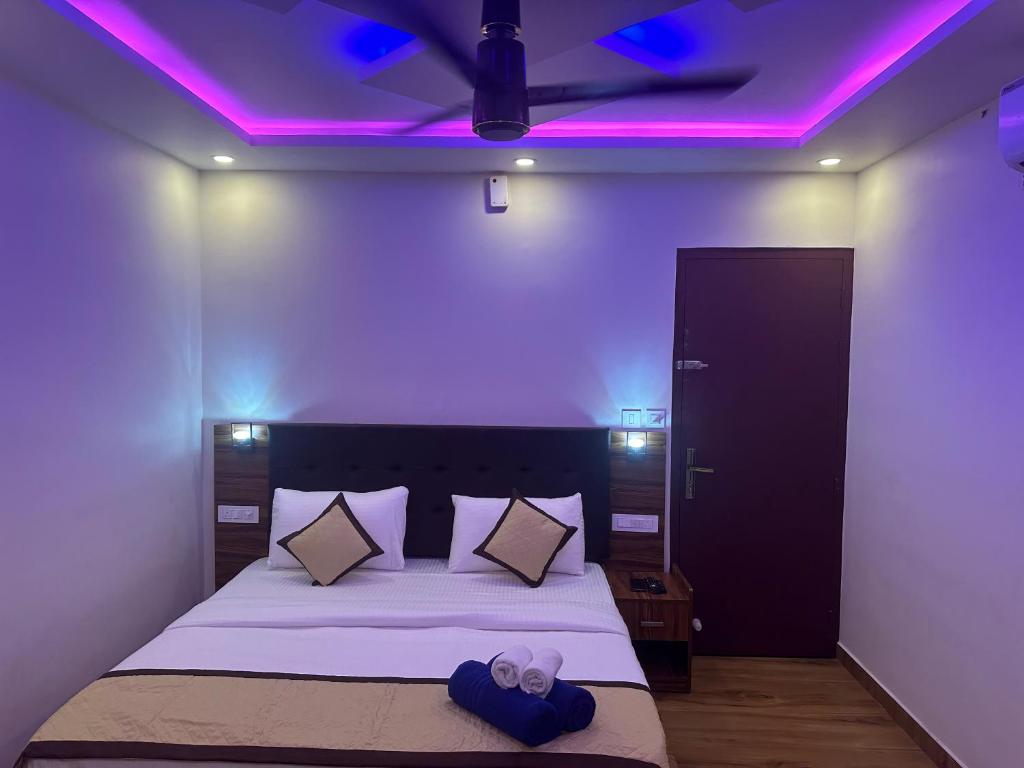 a bedroom with a bed with purple lights on it at Golden hills cottage in Viripara