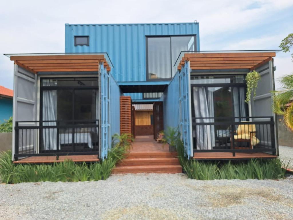 uma casa com fachada azul na praia em Pousada Ecoblue Container em Palhoça