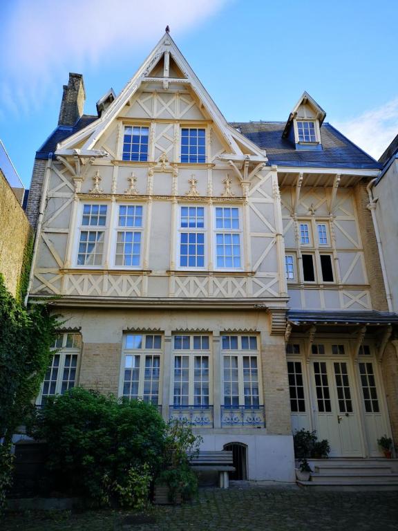 - un grand bâtiment avec des fenêtres et un banc devant dans l'établissement Les visages des Tournelles, à Reims