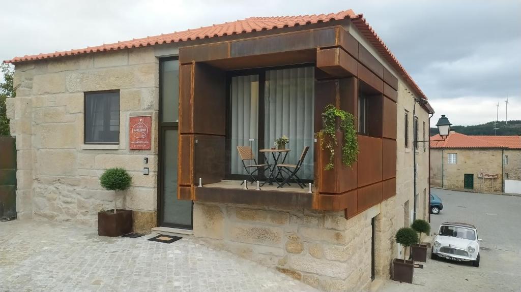 a building with a balcony with a table and chairs at Casas Martainha in Sernancelhe