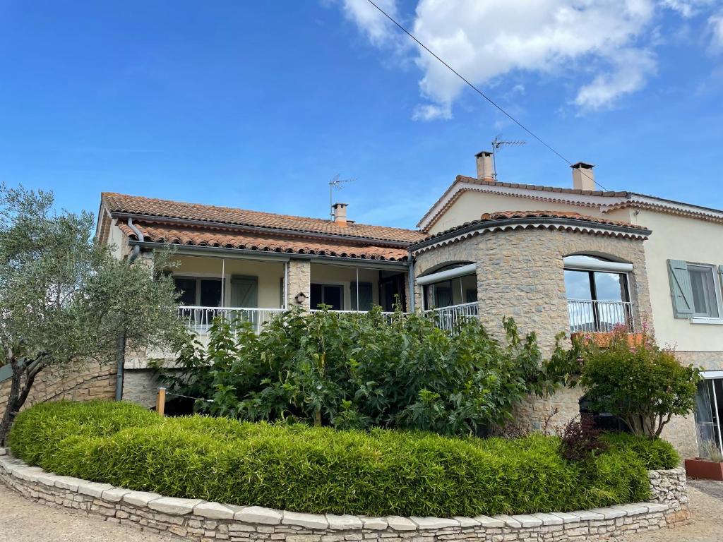 une maison en briques avec un jardin devant dans l'établissement Le petit Vialto, à Grospierres