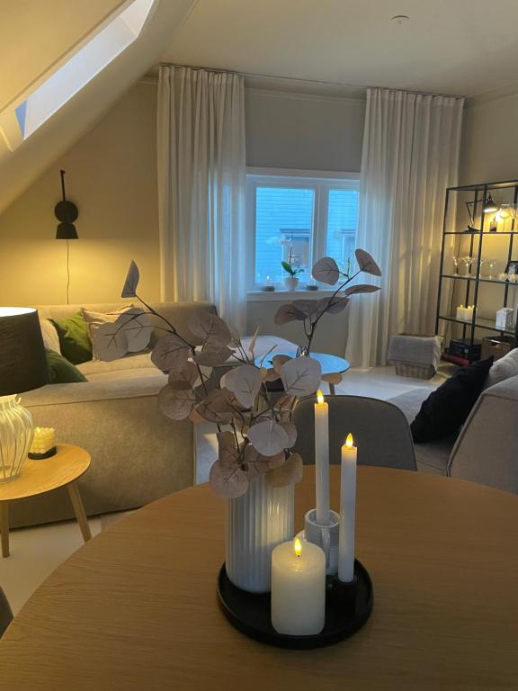 a living room with a vase with candles on a table at Apartment with free parking 350 m from the center of Ålesund private apartment in Ålesund