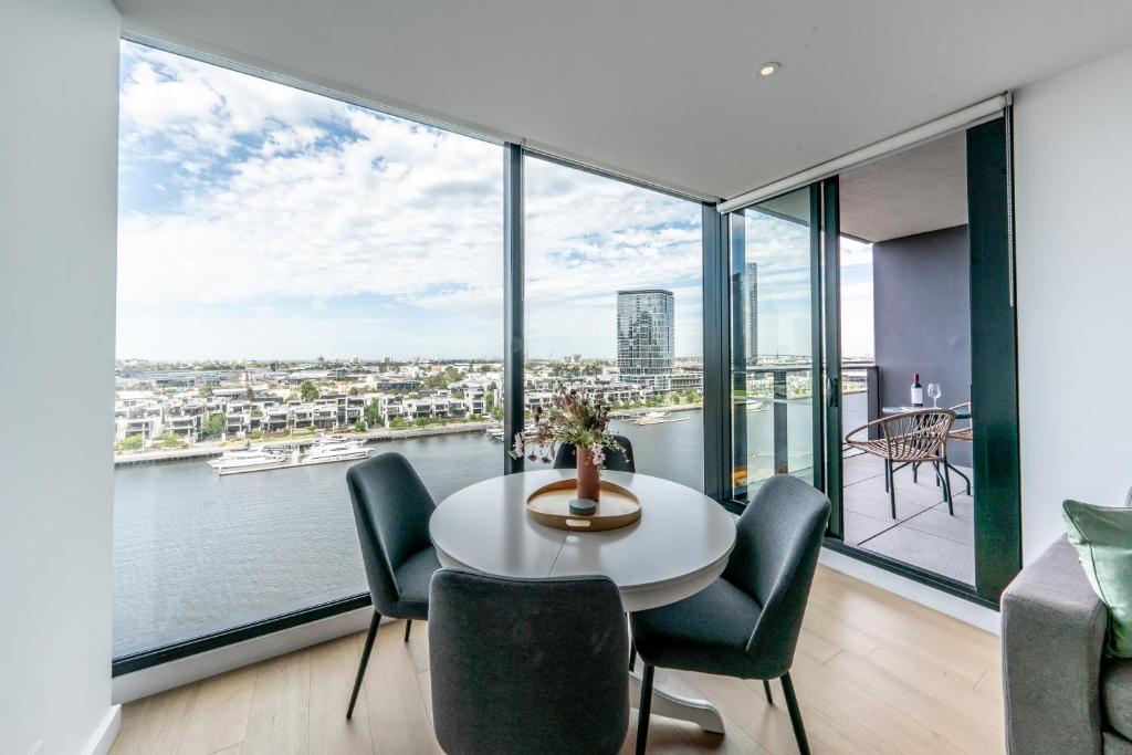 una stanza con un tavolo e sedie e una grande finestra di Melbourne Corporate Stays - Docklands Waterfront a Melbourne