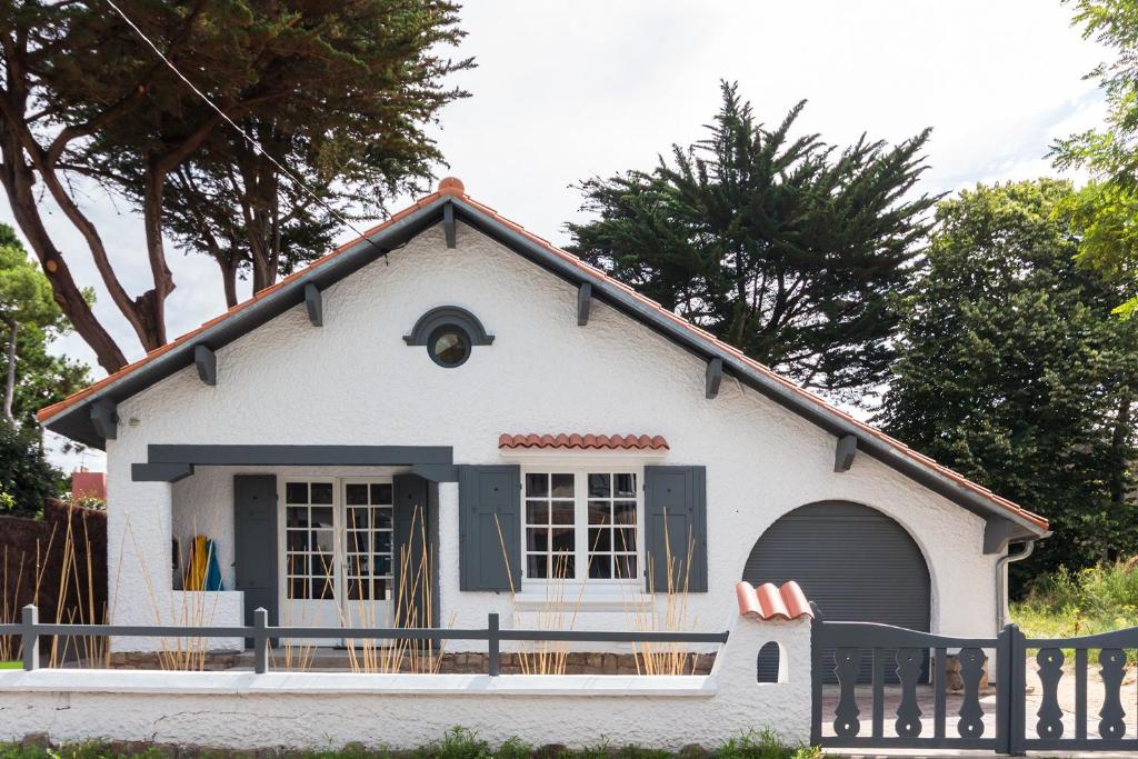 een klein wit huis met een veranda bij Proche plage et marché, grand jardin, barbecue 9 pers in La Baule