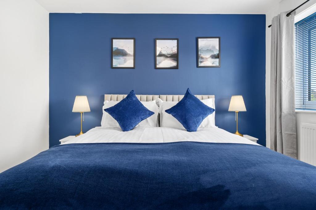 a blue bedroom with a large bed with blue walls at Superb Two Bedroom House Near Etihad & Coop Live - Free Parking in Manchester
