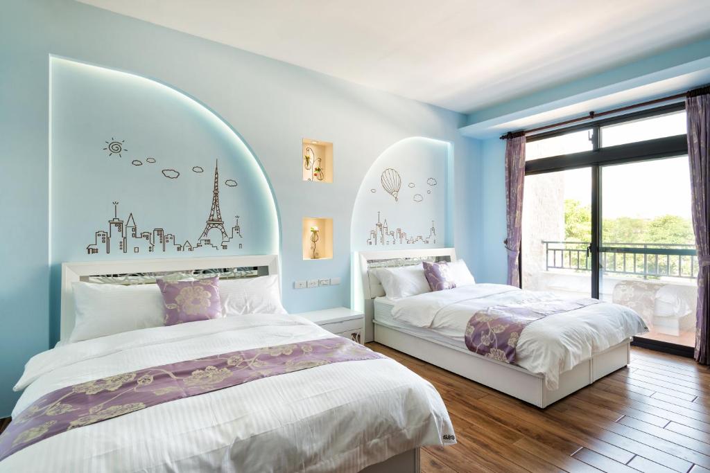 花蓮市的住宿－好趣淘休閒民宿 電梯 車位預約制，卧室设有两张床,拥有蓝色的墙壁和窗户。