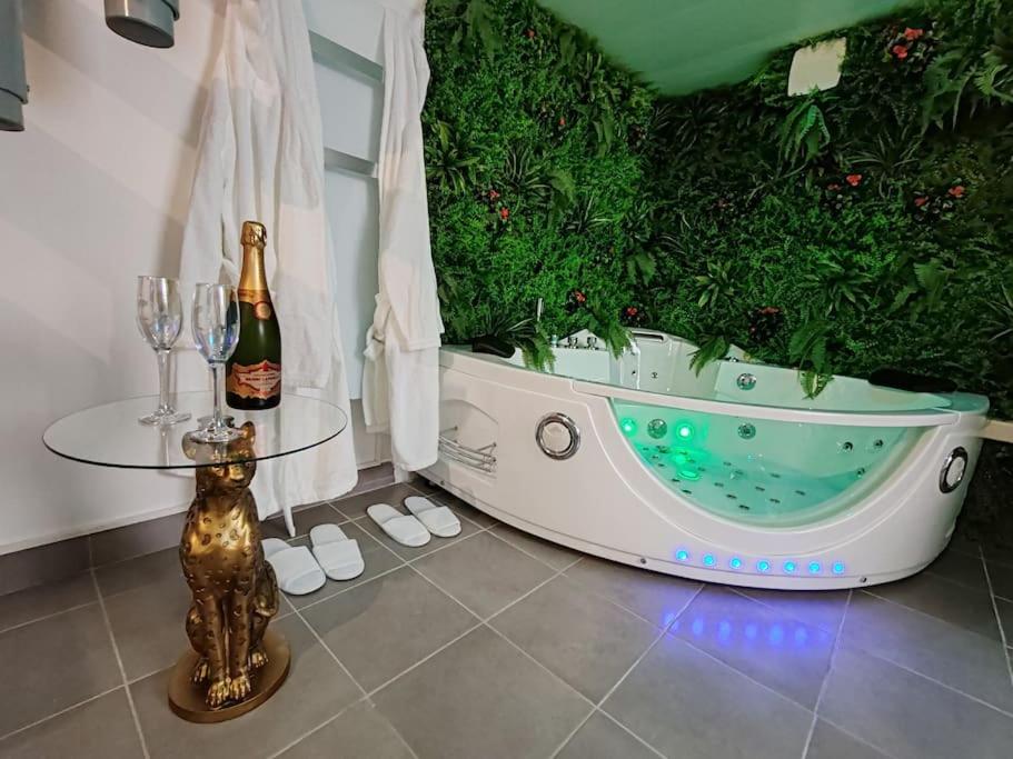 La salle de bains est pourvue d'une baignoire et d'une bouteille de champagne. dans l'établissement L'Eden, maison atypique, à Nancy